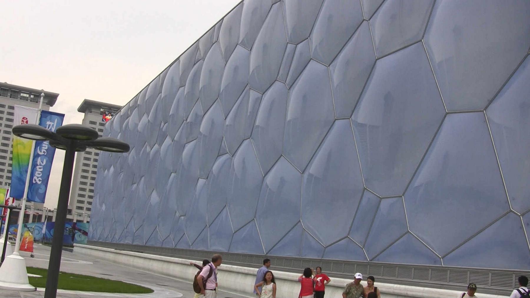 The distinctive bubble-like facade of the Beijing National Aquatics Center ("Water Cube") with visitors outside.