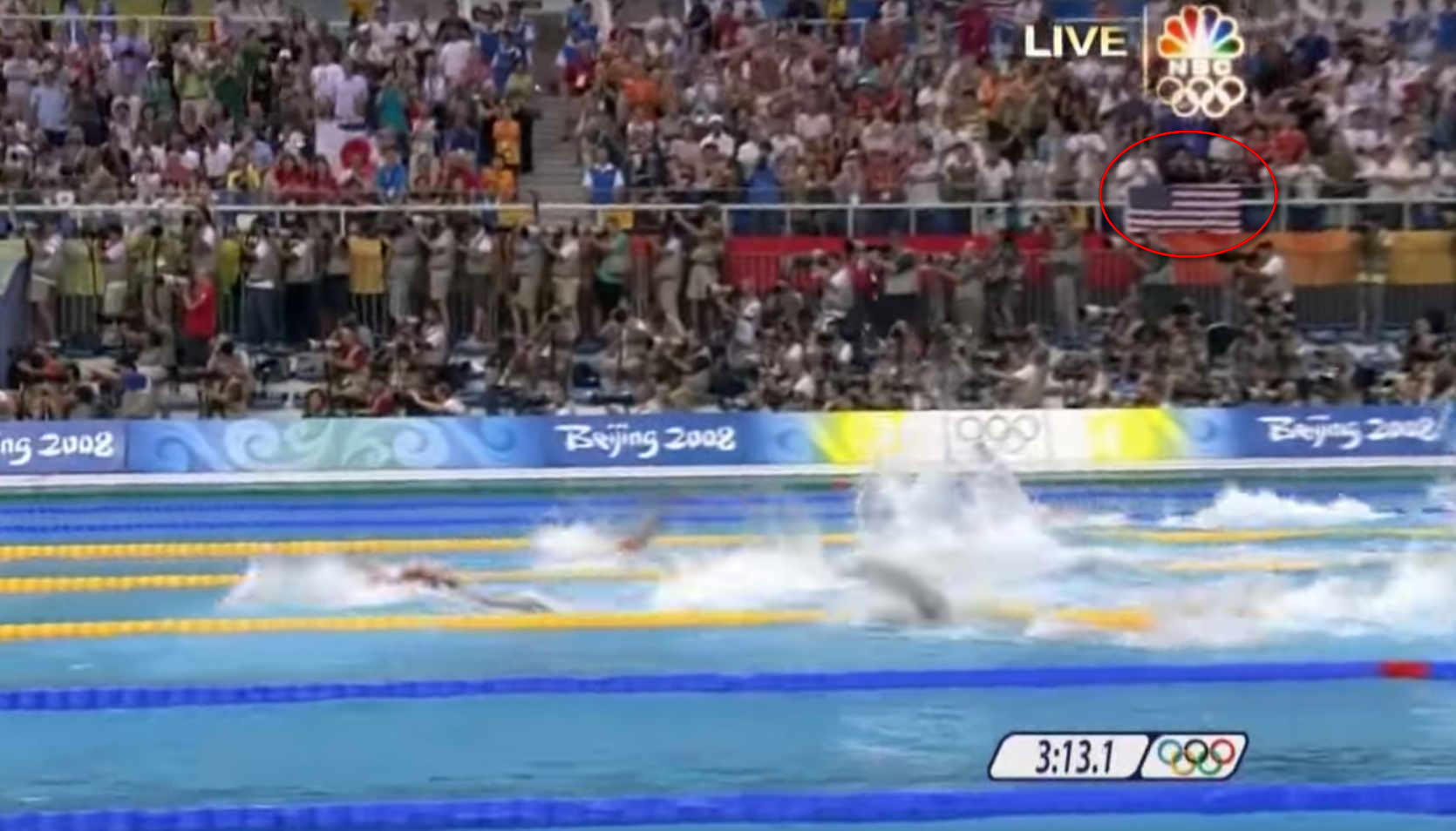 Swimmers compete in an Olympic race at Beijing 2008 as a large crowd watches.