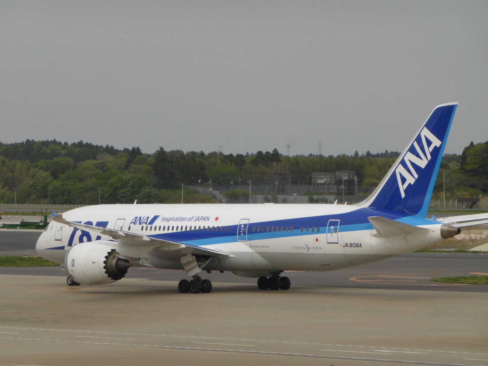 An ANA Boeing 787 Dreamliner aircraft is parked on the airport tarmac.