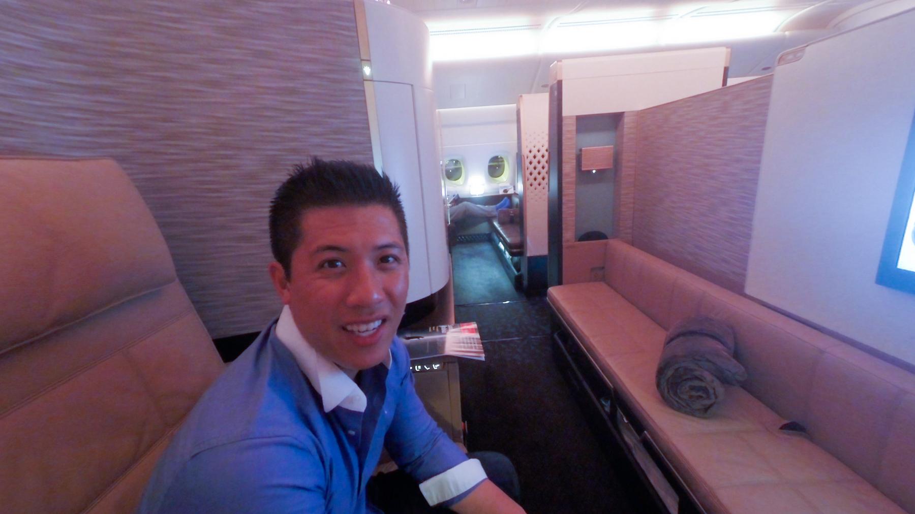 A smiling man sits in a luxurious Etihad A380 First Class apartment.