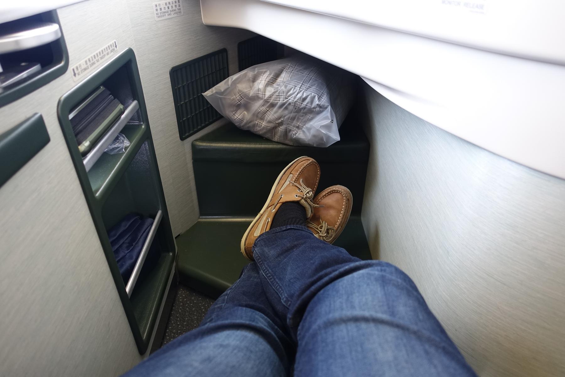 A traveler's feet rest in the spacious footwell of an Eva Air Royal Laurel business class seat.