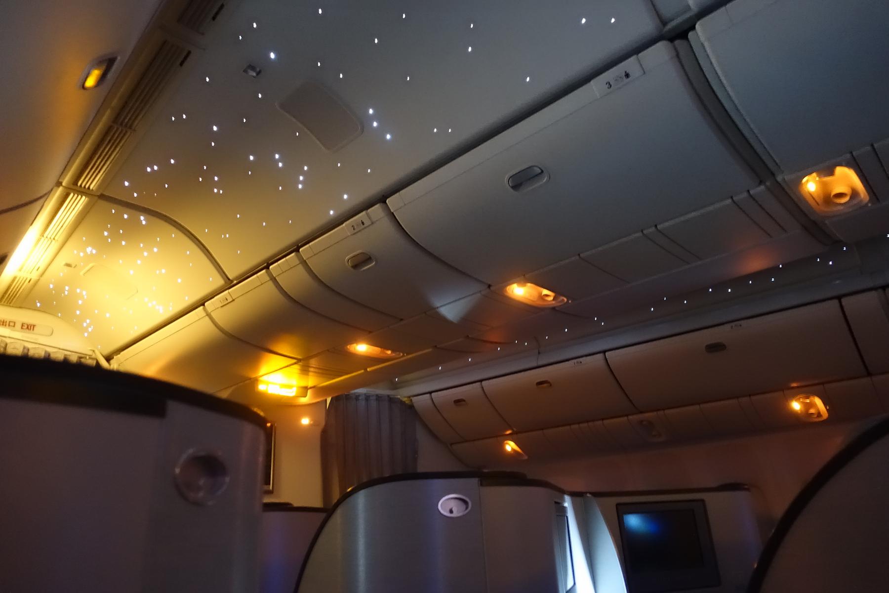 Eva Air business class cabin interior with a starry ceiling and amber ambient lighting.
