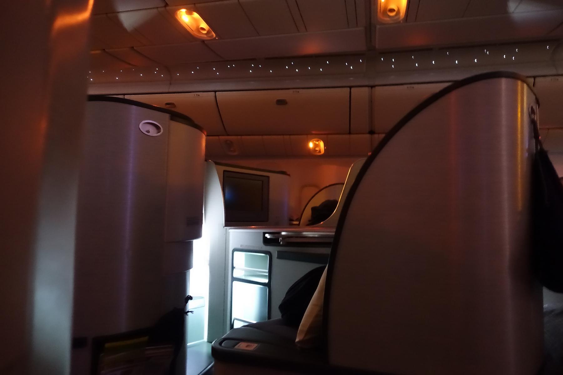 Eva Air Business Class cabin with individual pods, ambient lighting, and an open mini-bar.
