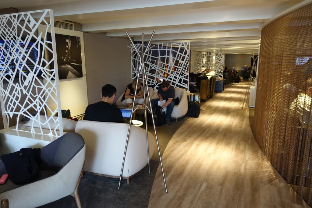 Travelers relax and work in a modern Eva Air Business Class airport lounge.