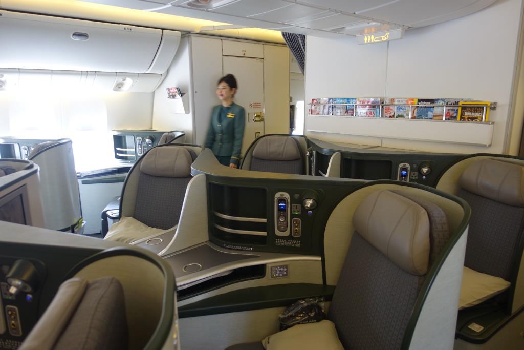 Eva Air Royal Laurel Business Class cabin featuring spacious individual pod-style seats and a flight attendant.