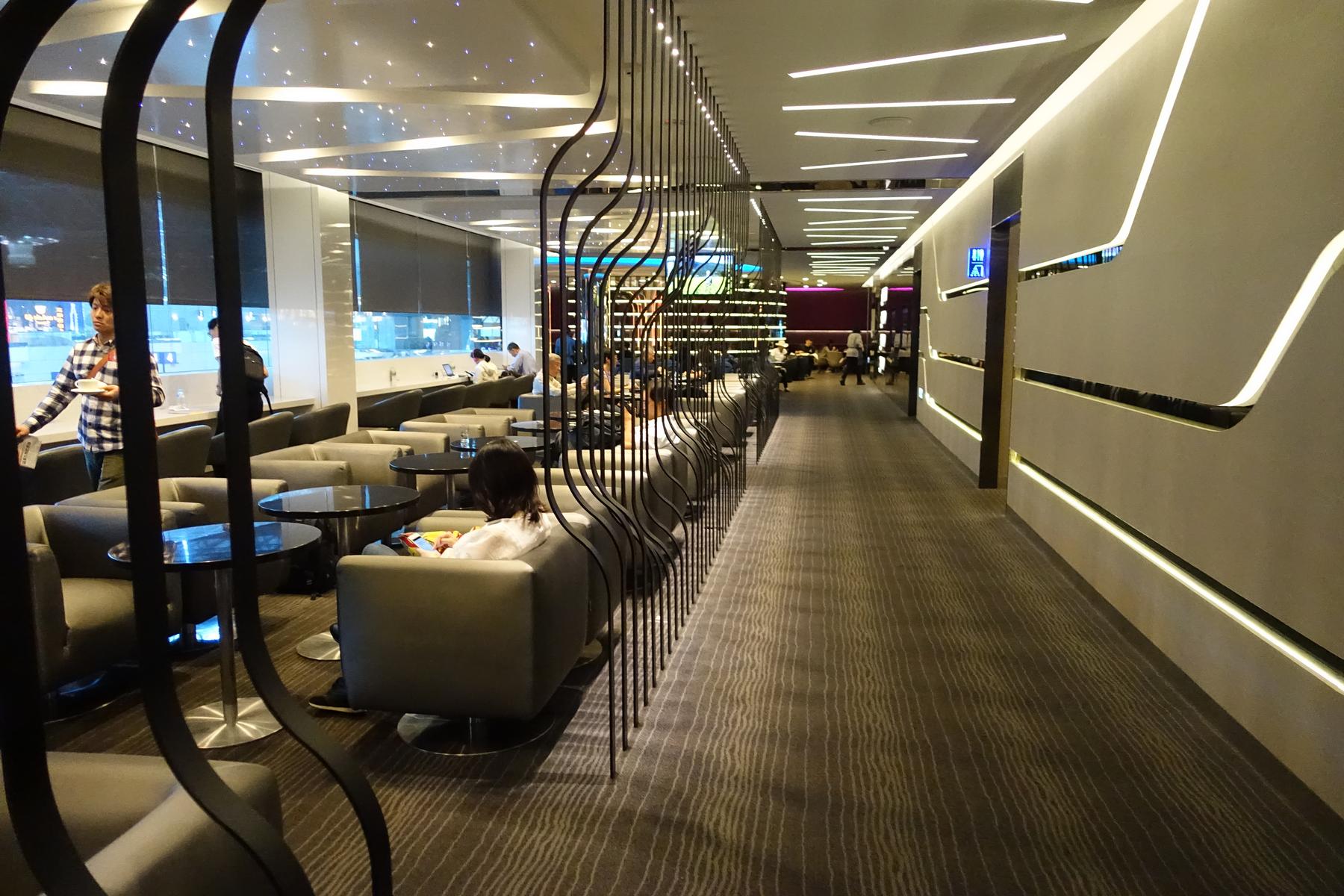 Modern Eva Air Business Class Lounge interior with comfortable seating areas and people relaxing.