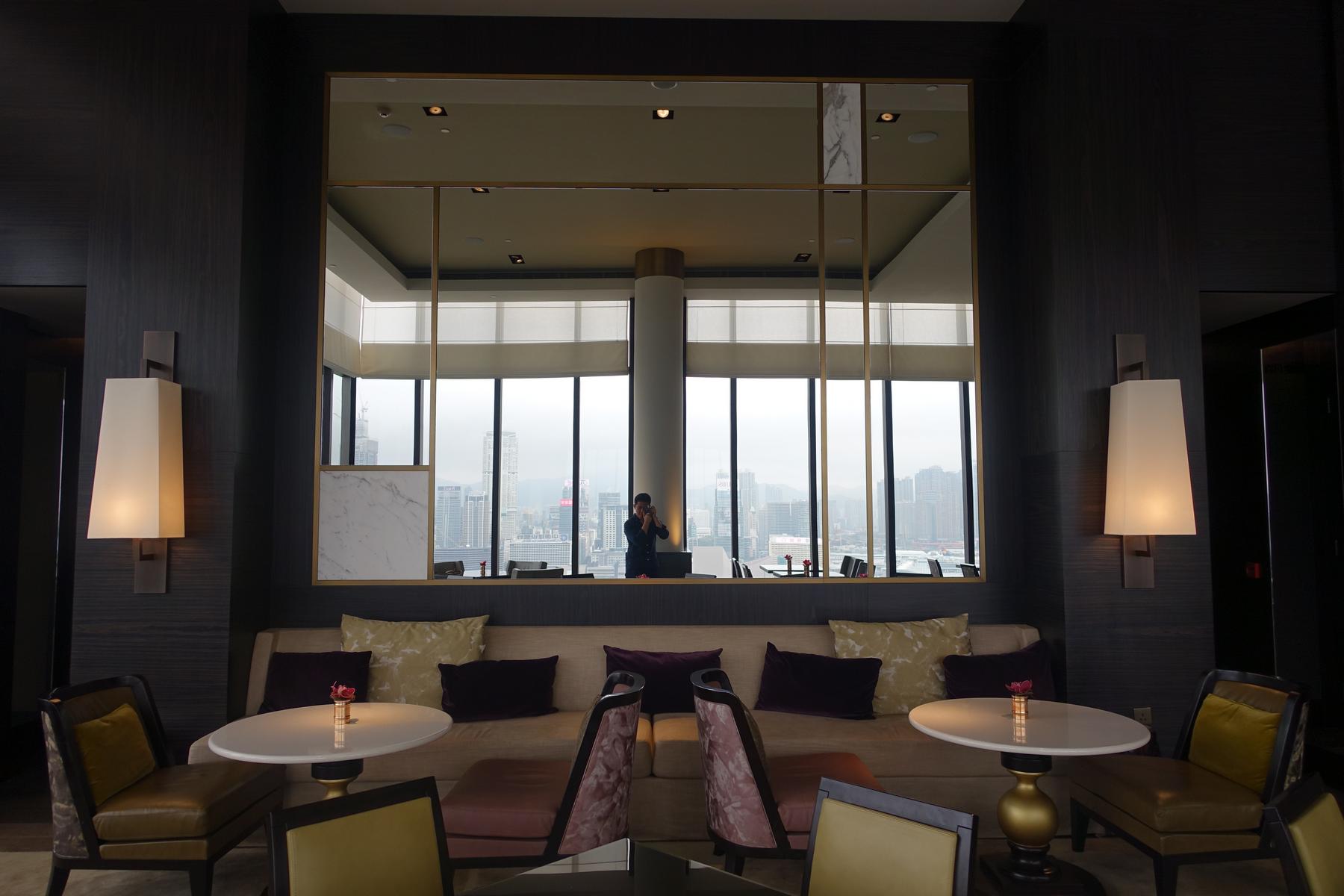 The renovated Grand Club Lounge featuring elegant seating, a large mirror, and city views.