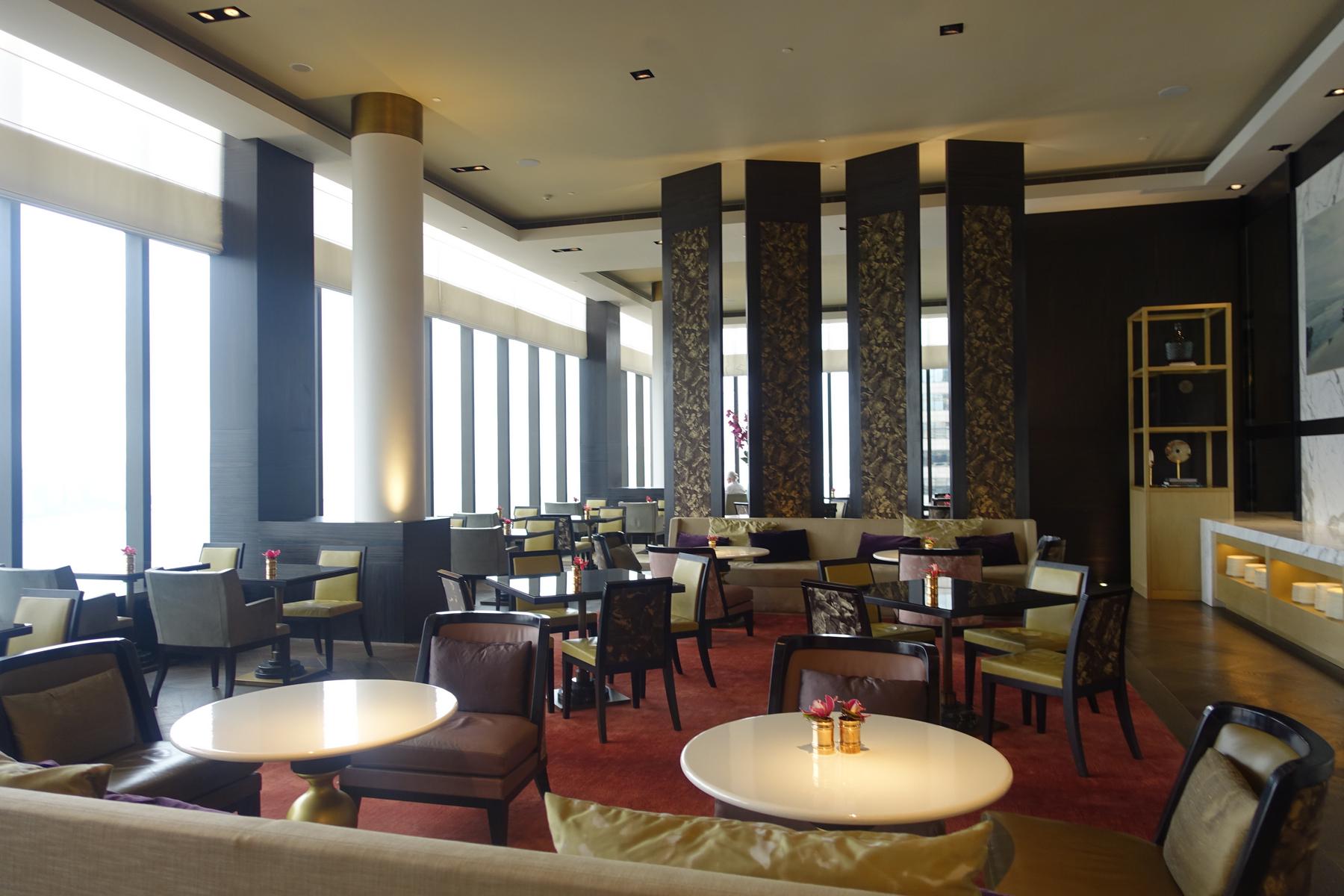 A modern, renovated hotel lounge featuring large windows and various seating areas.