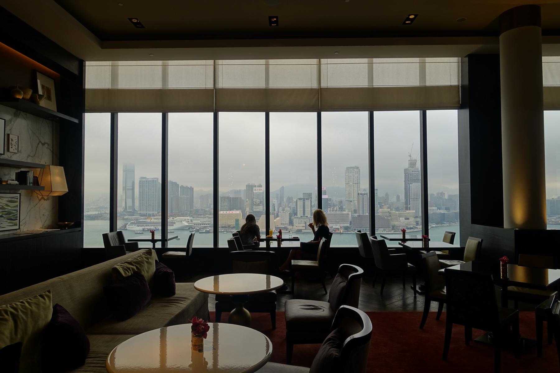 The renovated Grand Club Lounge at Grand Hyatt Hong Kong, featuring large windows with views of the city skyline and harbor.