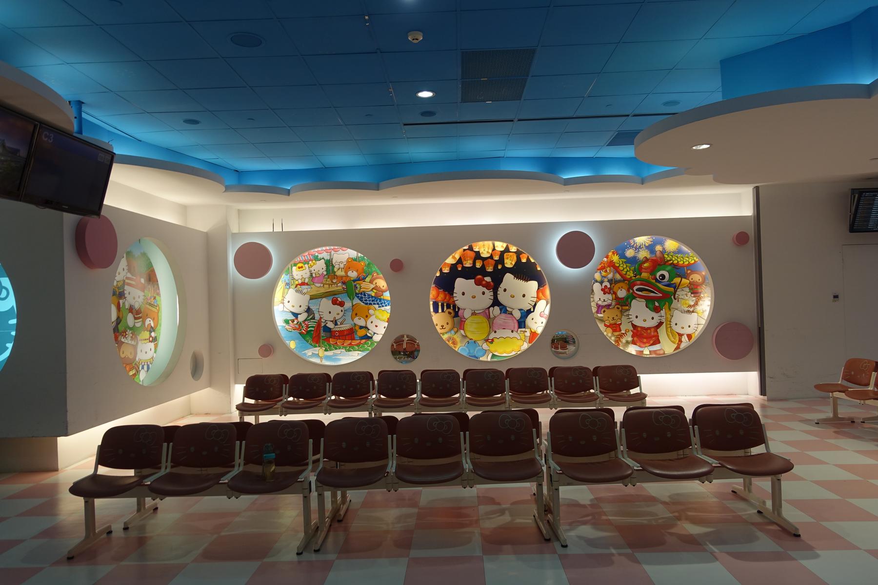 Hello Kitty themed airport lounge with rows of branded seats and large character murals.
