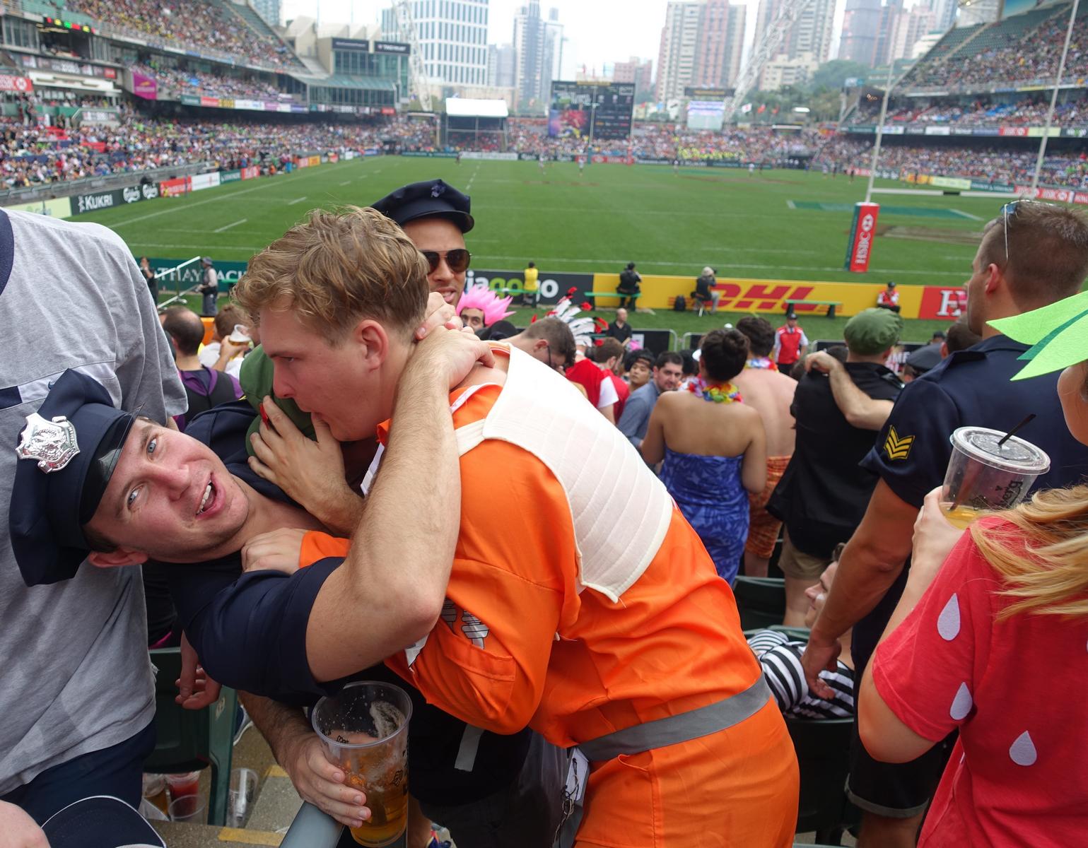 Two costumed fans, one as a police officer and one in an orange jumpsuit, celebrate at the Hong Kong Rugby Sevens.