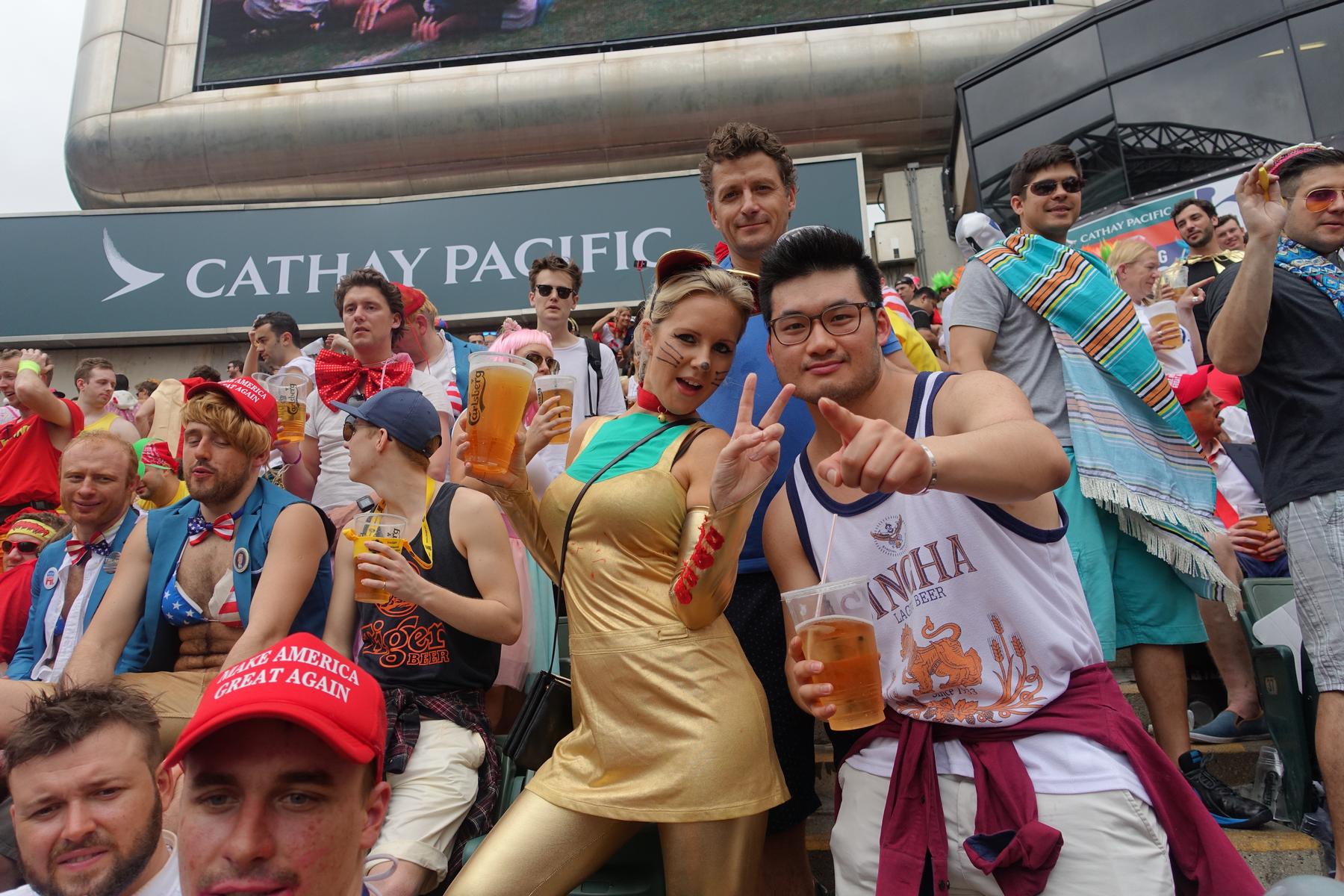 Costumed fans with beers pose for a photo in the lively South Stand at the Hong Kong Rugby Sevens.