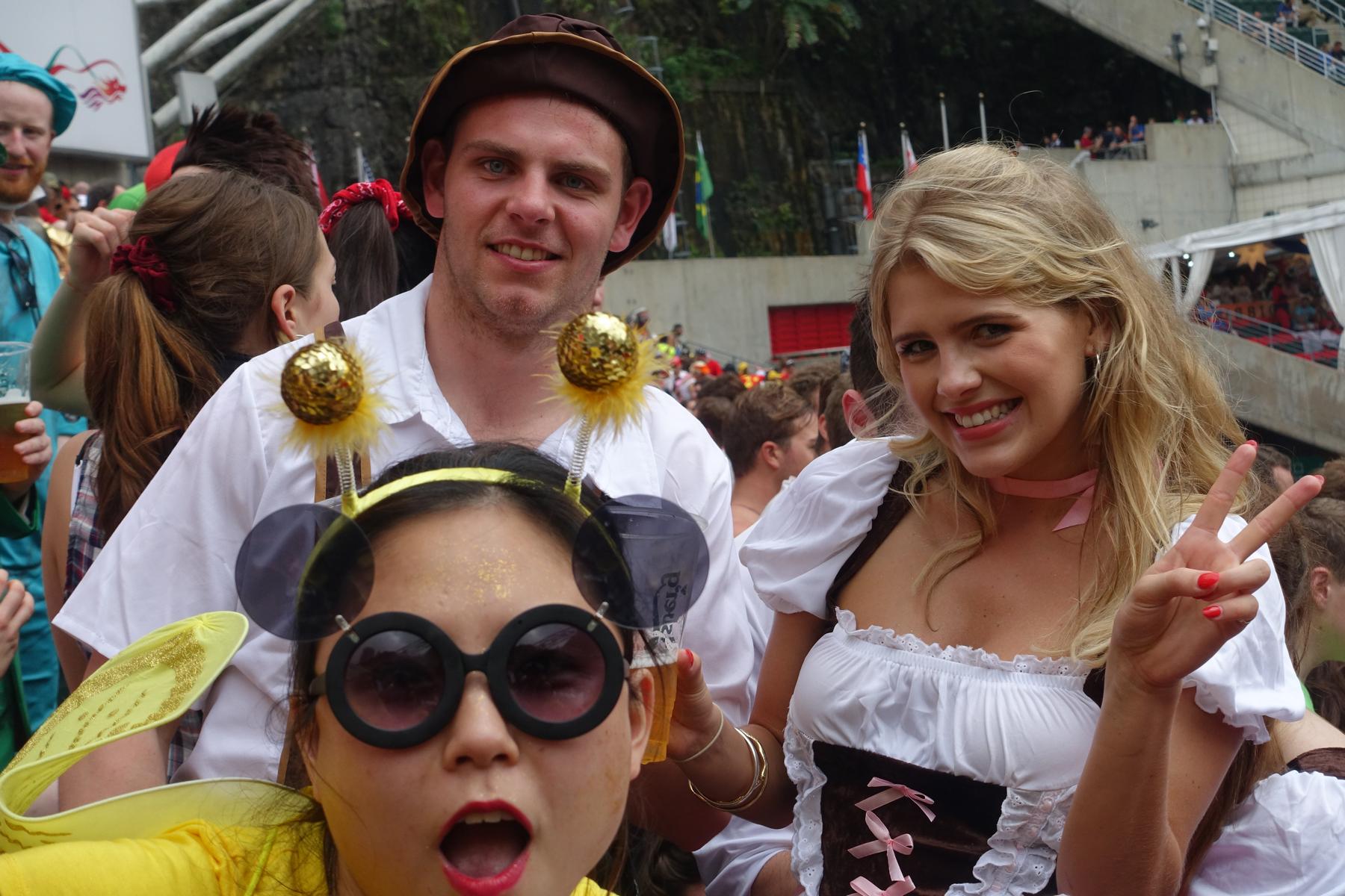 Costumed fans smile and pose in the crowded Hong Kong Rugby Sevens South Stand.