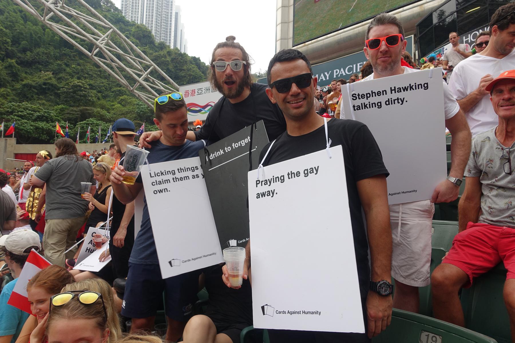 Men at the Hong Kong Rugby Sevens wear sandwich boards featuring phrases from the game Cards Against Humanity.