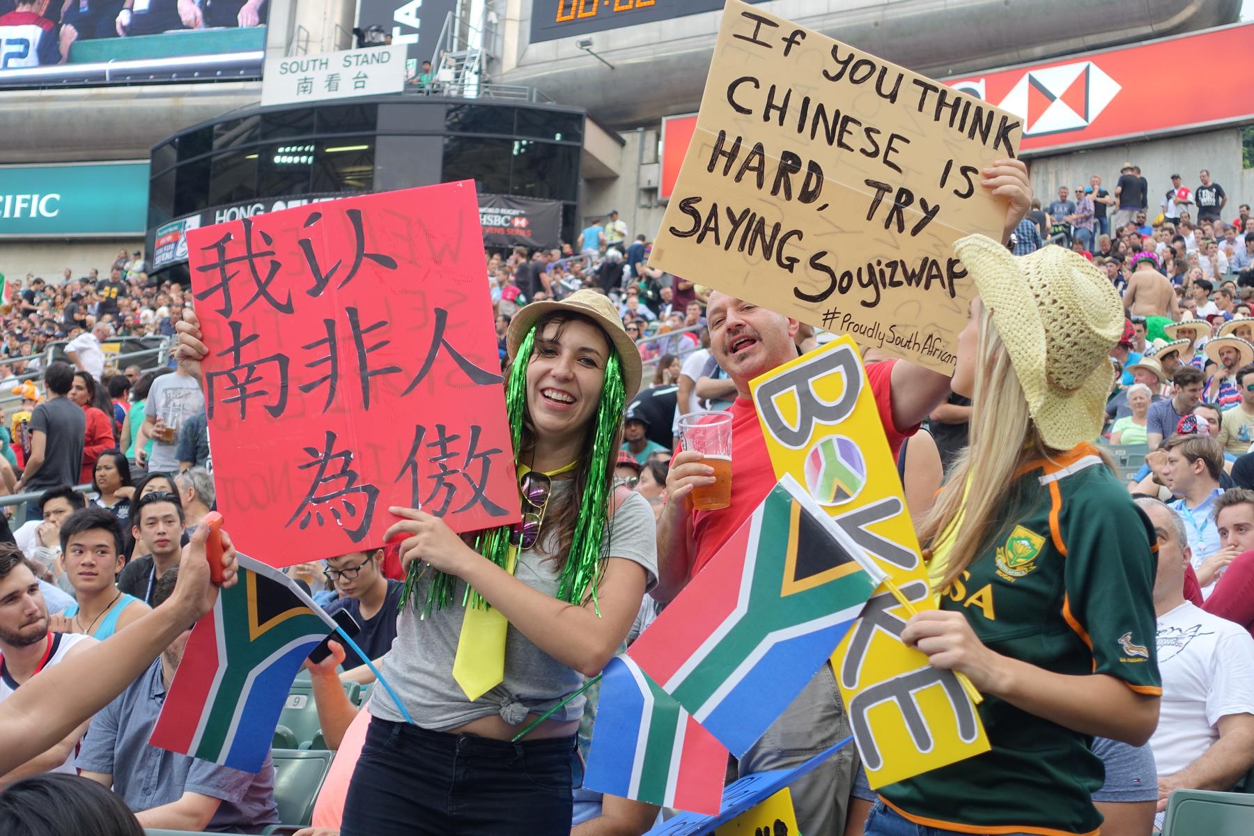 South African fans at Hong Kong Sevens hold signs proclaiming national pride, one written in Chinese.