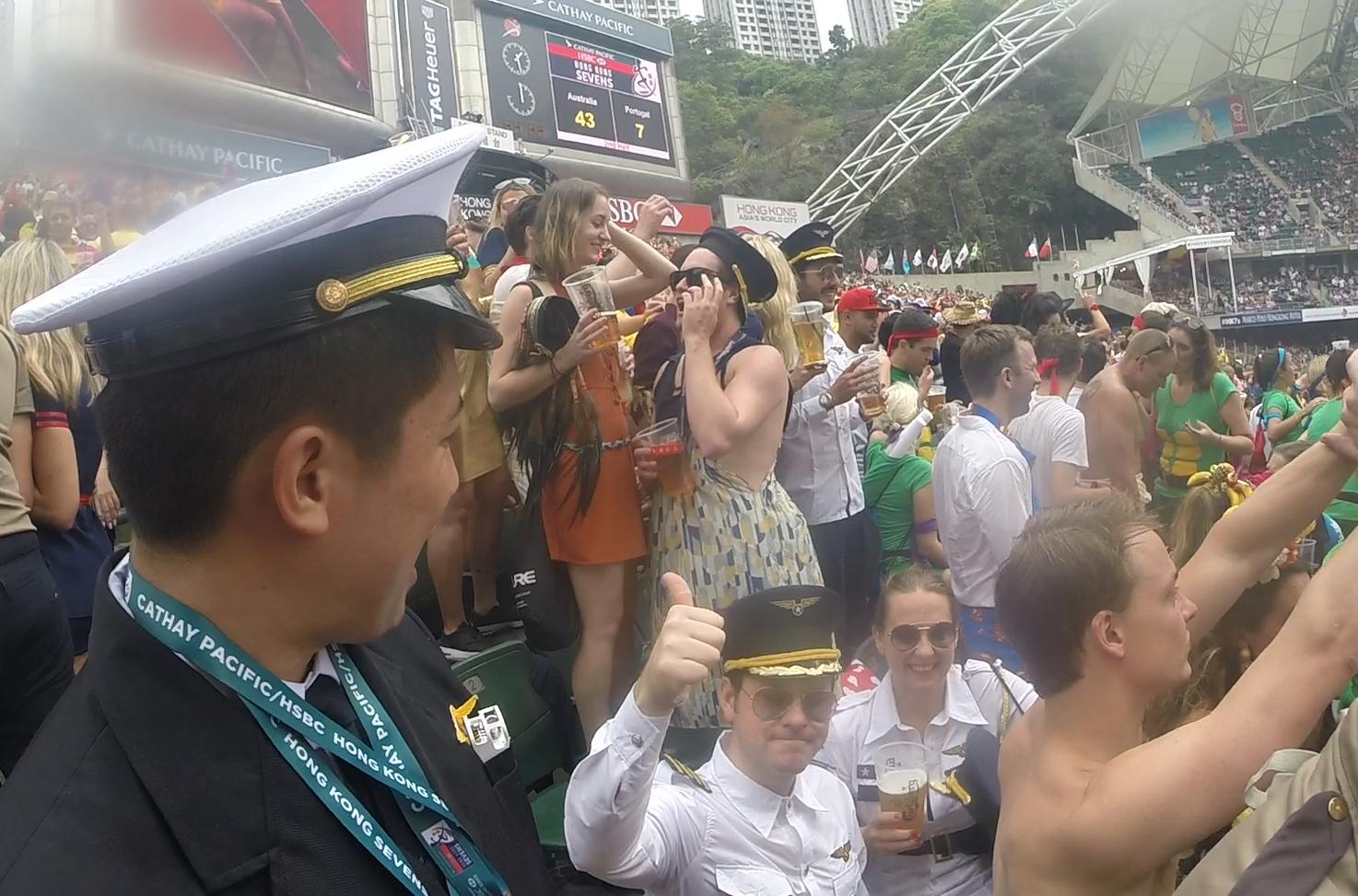 Spectators in costumes enjoy drinks and the festive atmosphere at the Hong Kong Sevens rugby tournament.
