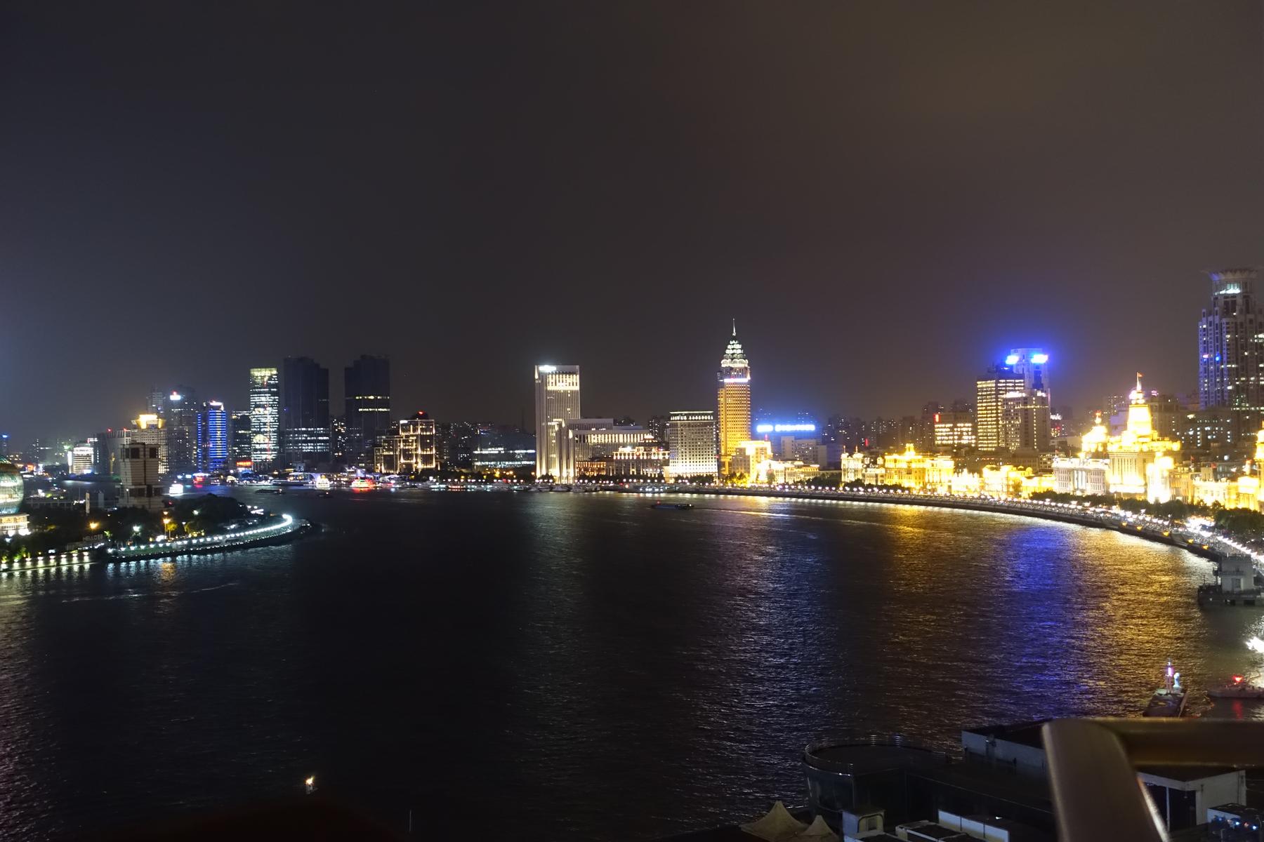 Night view of the illuminated Shanghai Bund skyline and river.