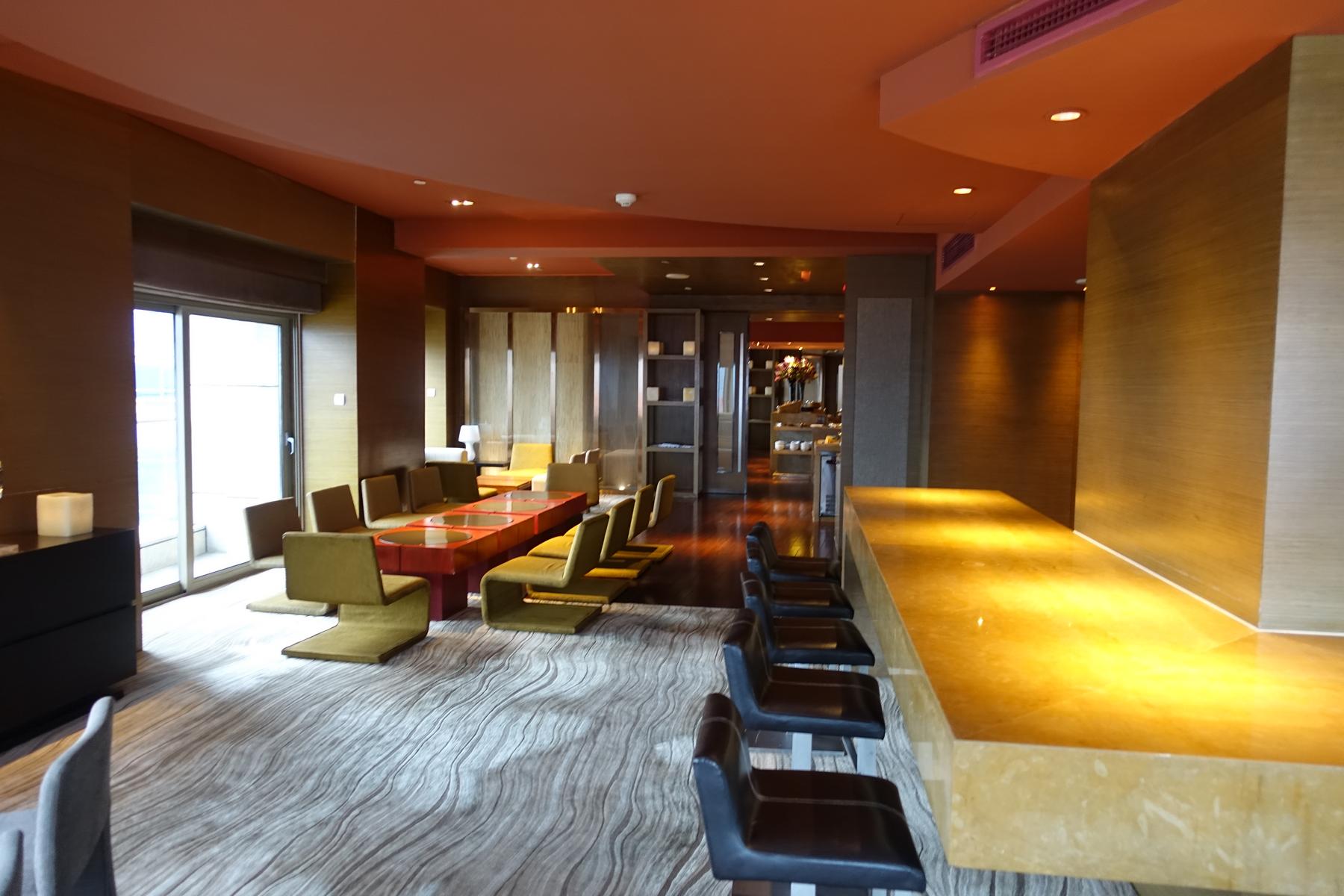 Modern club lounge at the Hyatt on the Bund, featuring diverse seating and a long bar.