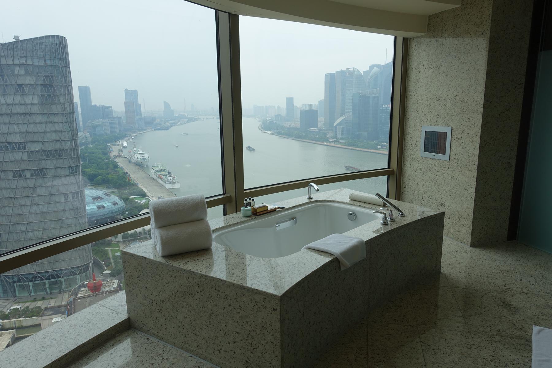 A hotel suite's bathtub offers panoramic views of the Shanghai skyline and Huangpu River.