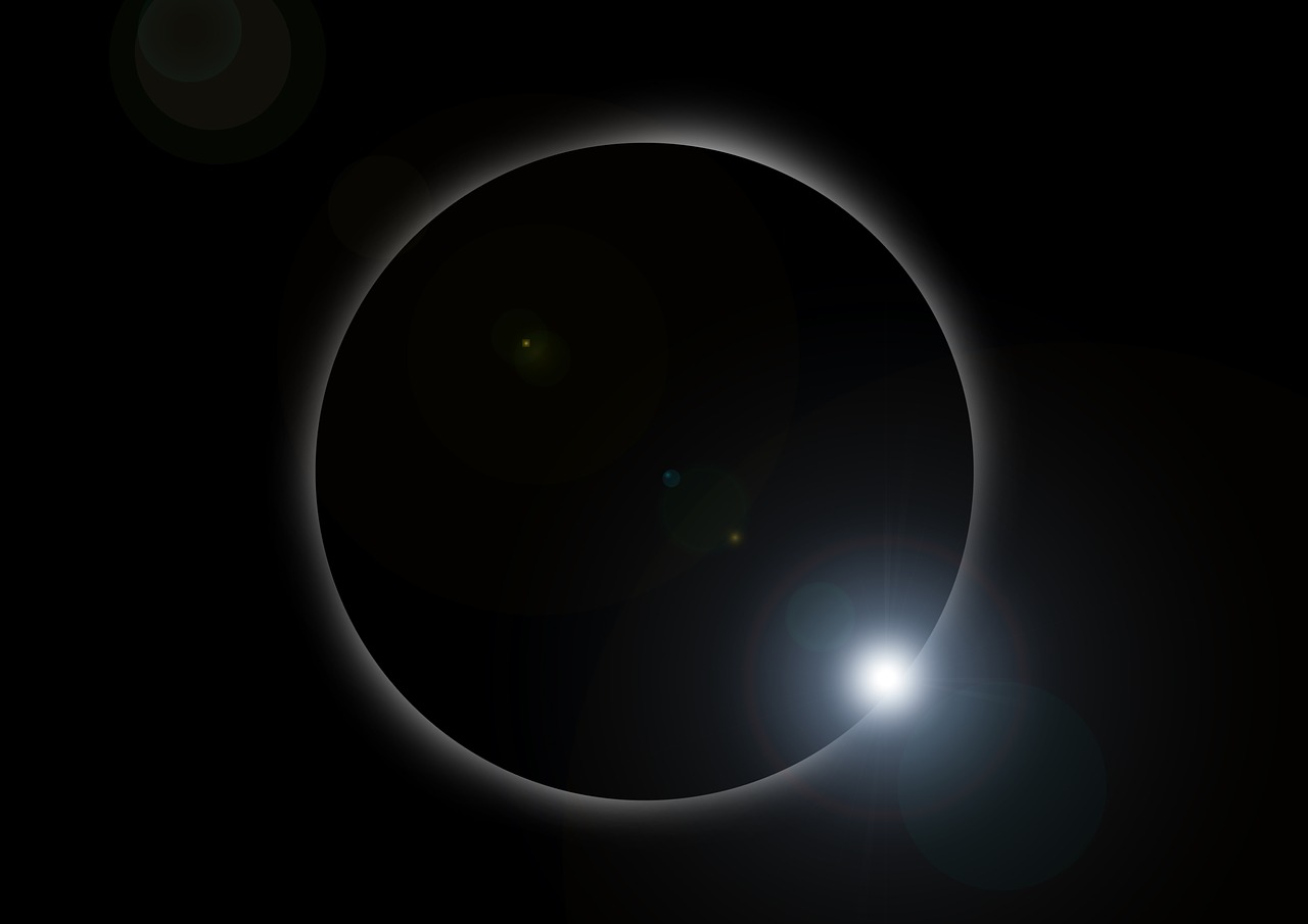 A solar eclipse showing the diamond ring effect with a bright light on its lower right edge.