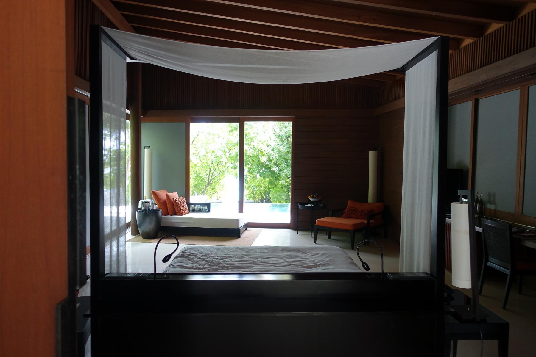 A luxurious bedroom in a Park Hyatt Maldives Pool Villa with a private plunge pool and lush green views.