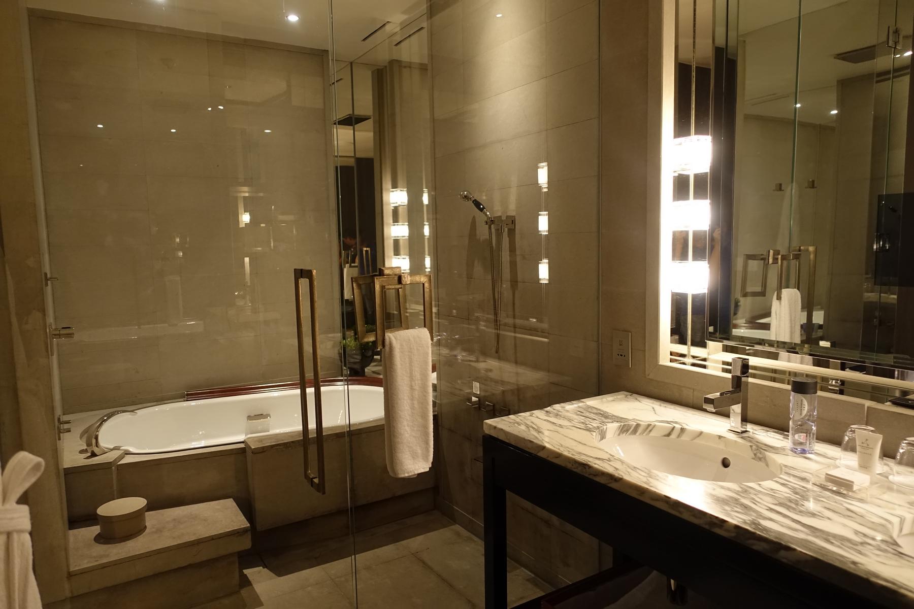 A luxurious bathroom with a freestanding bathtub, glass-enclosed shower, and marble vanity.