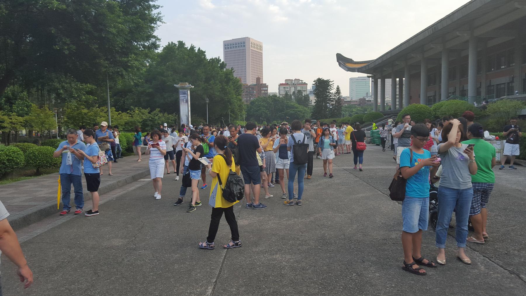 A large crowd in Taiwan with most people looking at their phones.
