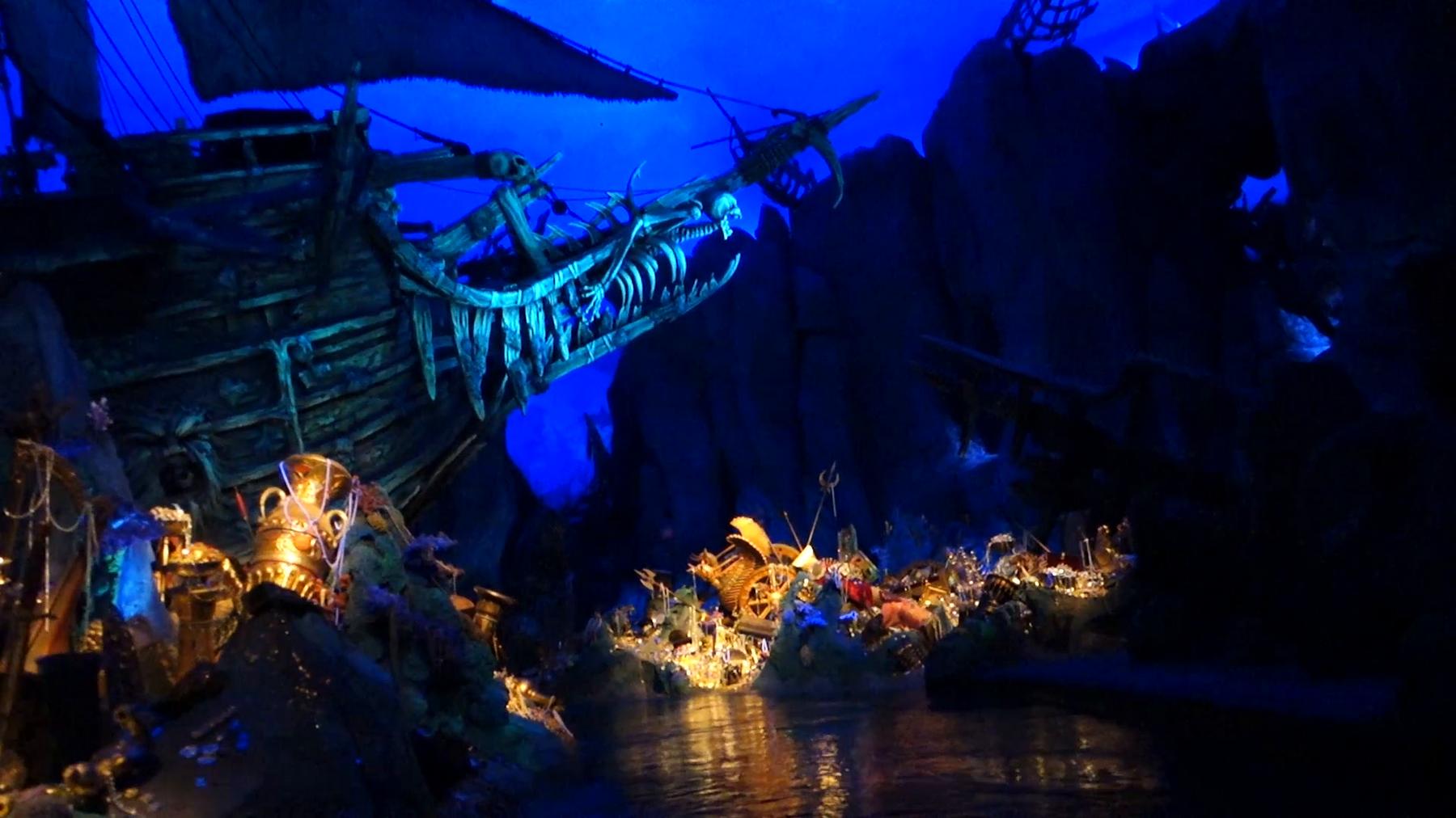 Shanghai Disneyland Pirates of the Caribbean ride featuring a skeletal ship and glowing gold treasure.