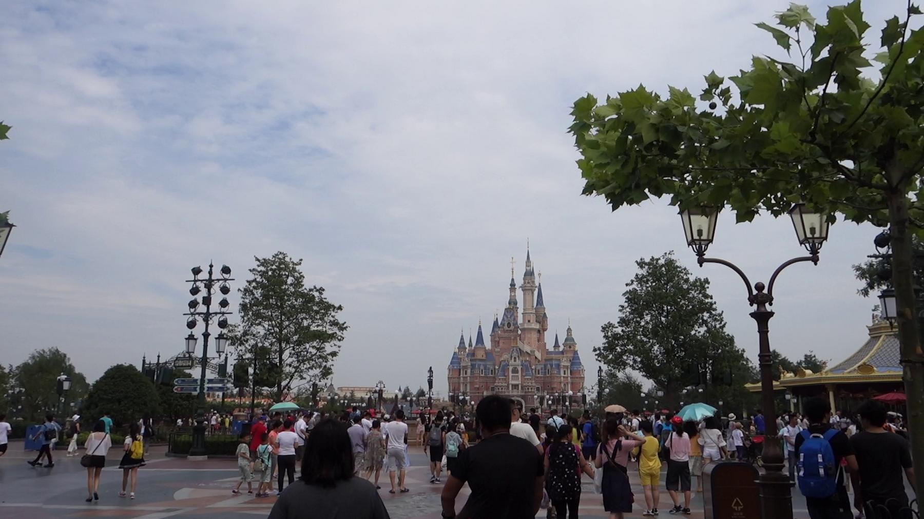 Crowds of visitors walk towards the Enchanted Storybook Castle at Disneyland Shanghai.