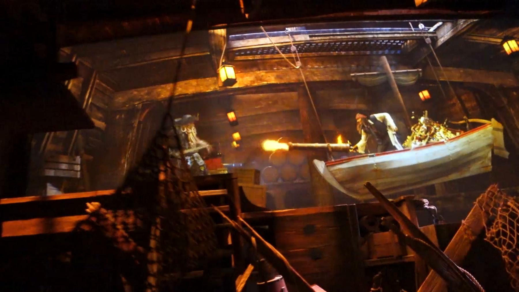 An animatronic pirate fires a cannon from a boat filled with treasure on the Pirates of the Caribbean ride.