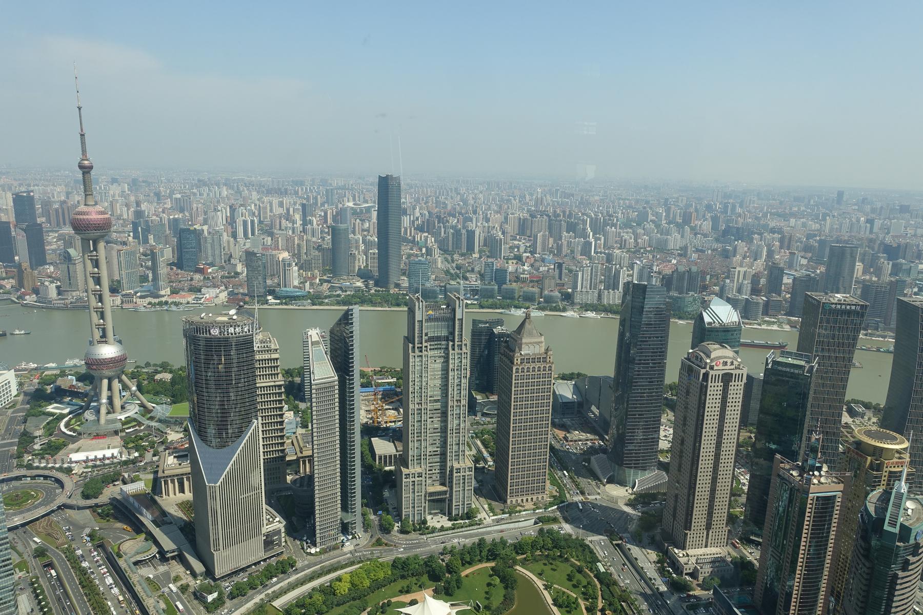 Panoramic view of the Shanghai skyline featuring the Oriental Pearl TV Tower and the Huangpu River.