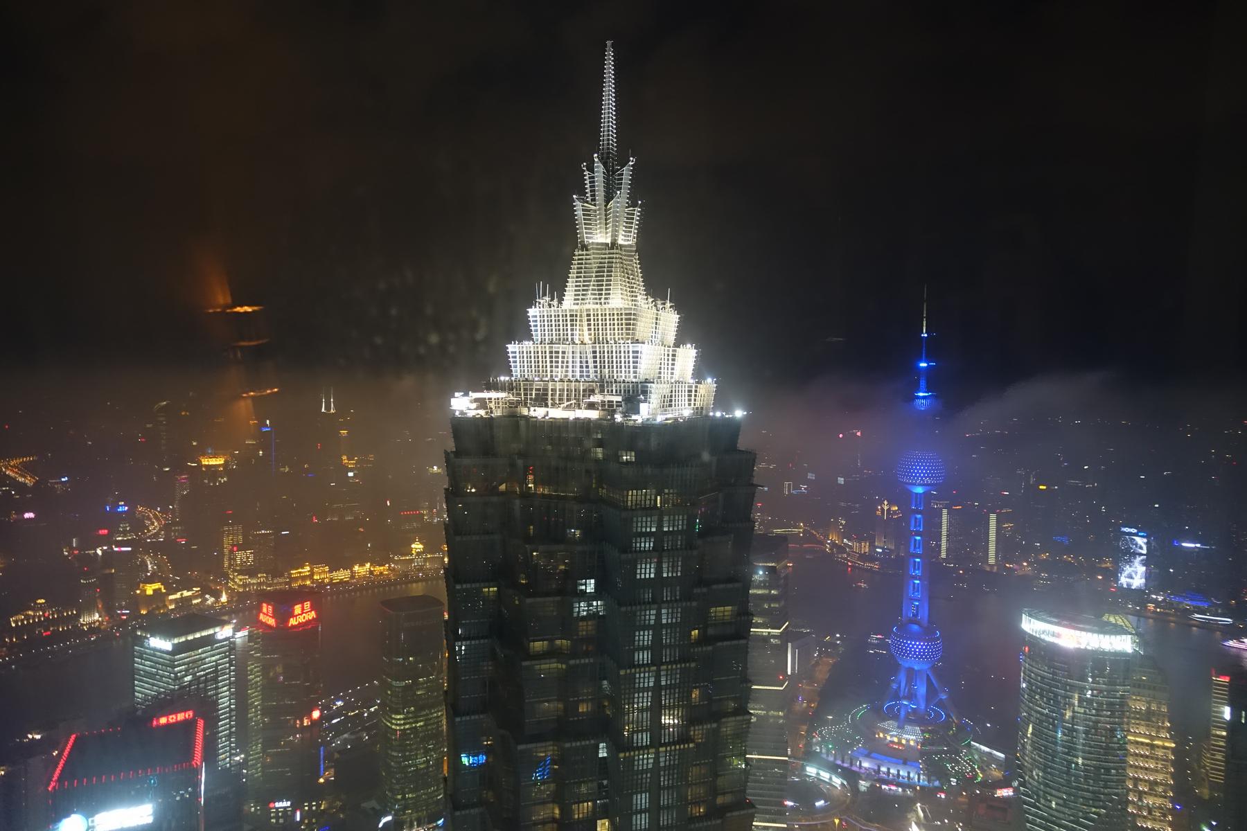 High-angle night view of Shanghai's illuminated skyline with the Jin Mao Tower and Oriental Pearl TV Tower.