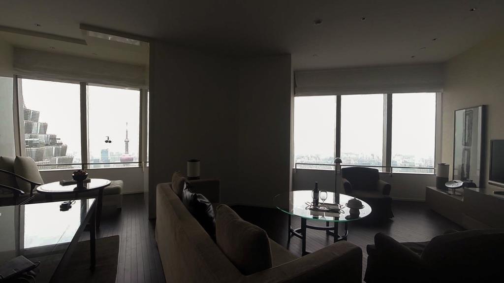 Luxury suite living room with panoramic Shanghai skyline view, featuring the Oriental Pearl TV Tower.