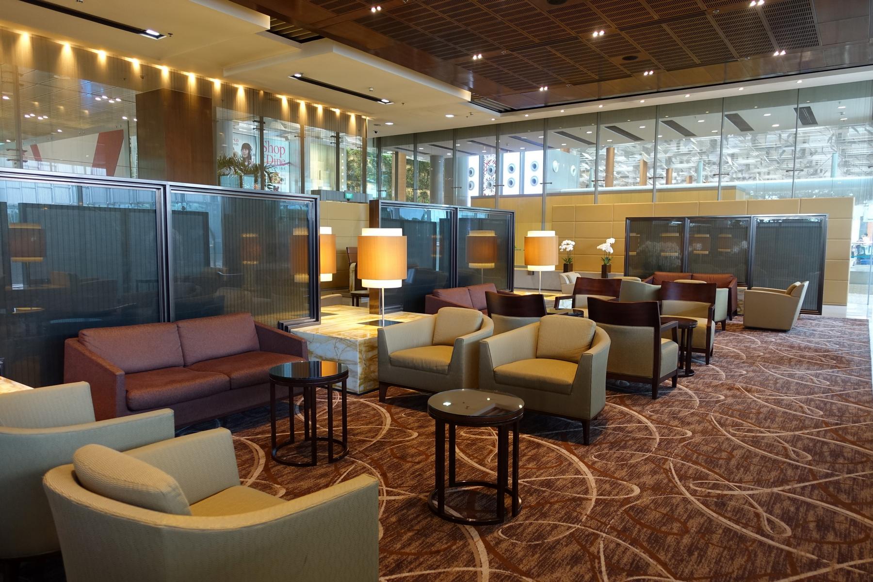 A luxurious airport lounge featuring various comfortable seating arrangements and ambient lighting.