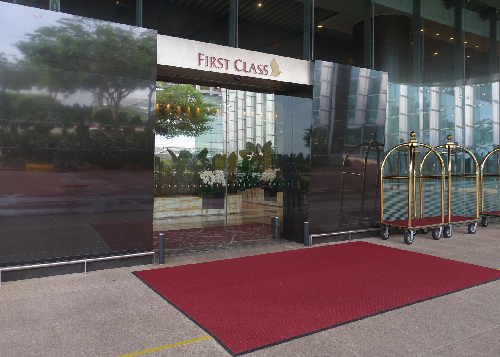 First Class entrance with a red carpet and gold luggage carts.