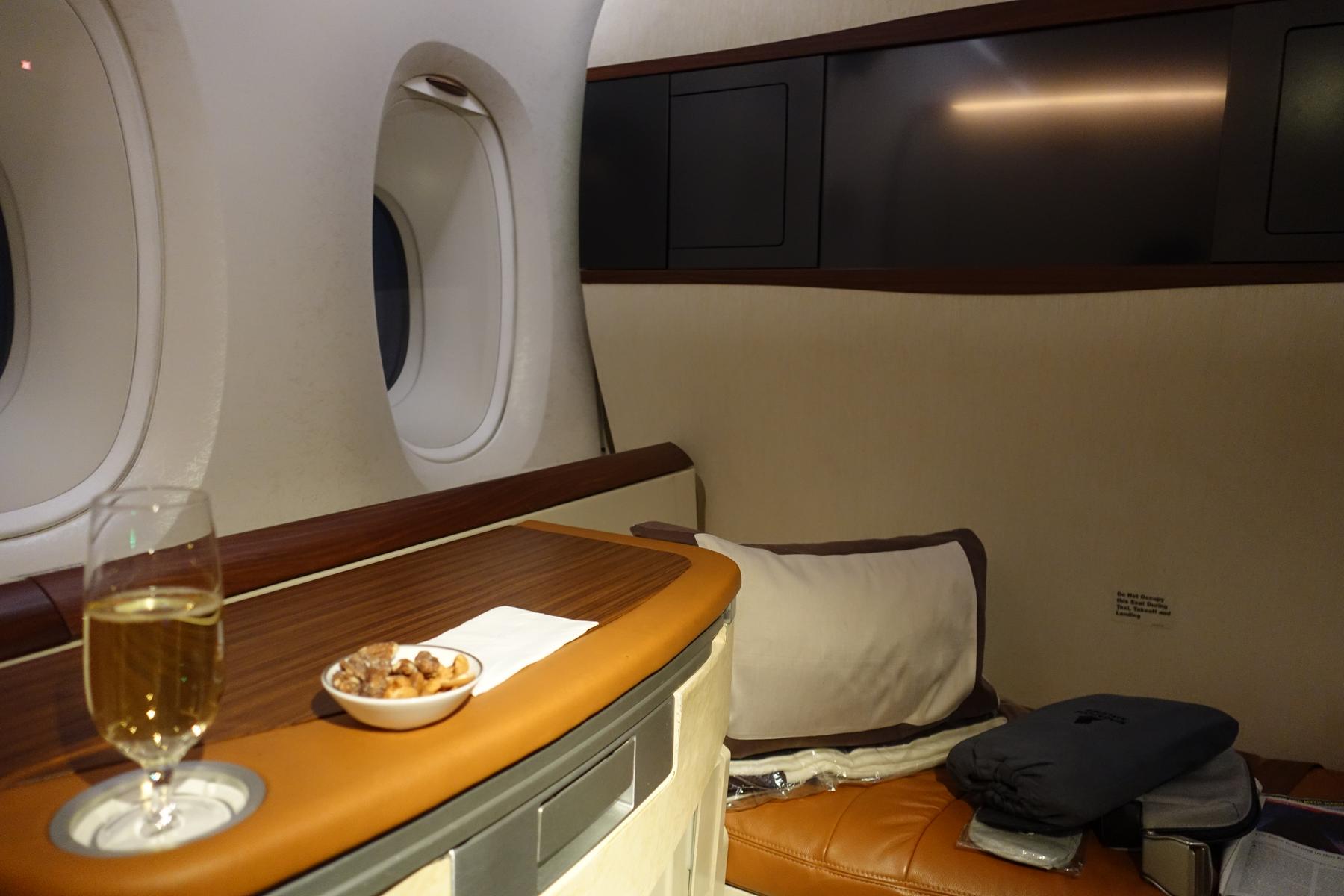 Singapore Airlines Suites Class interior featuring a window, champagne, and snacks.