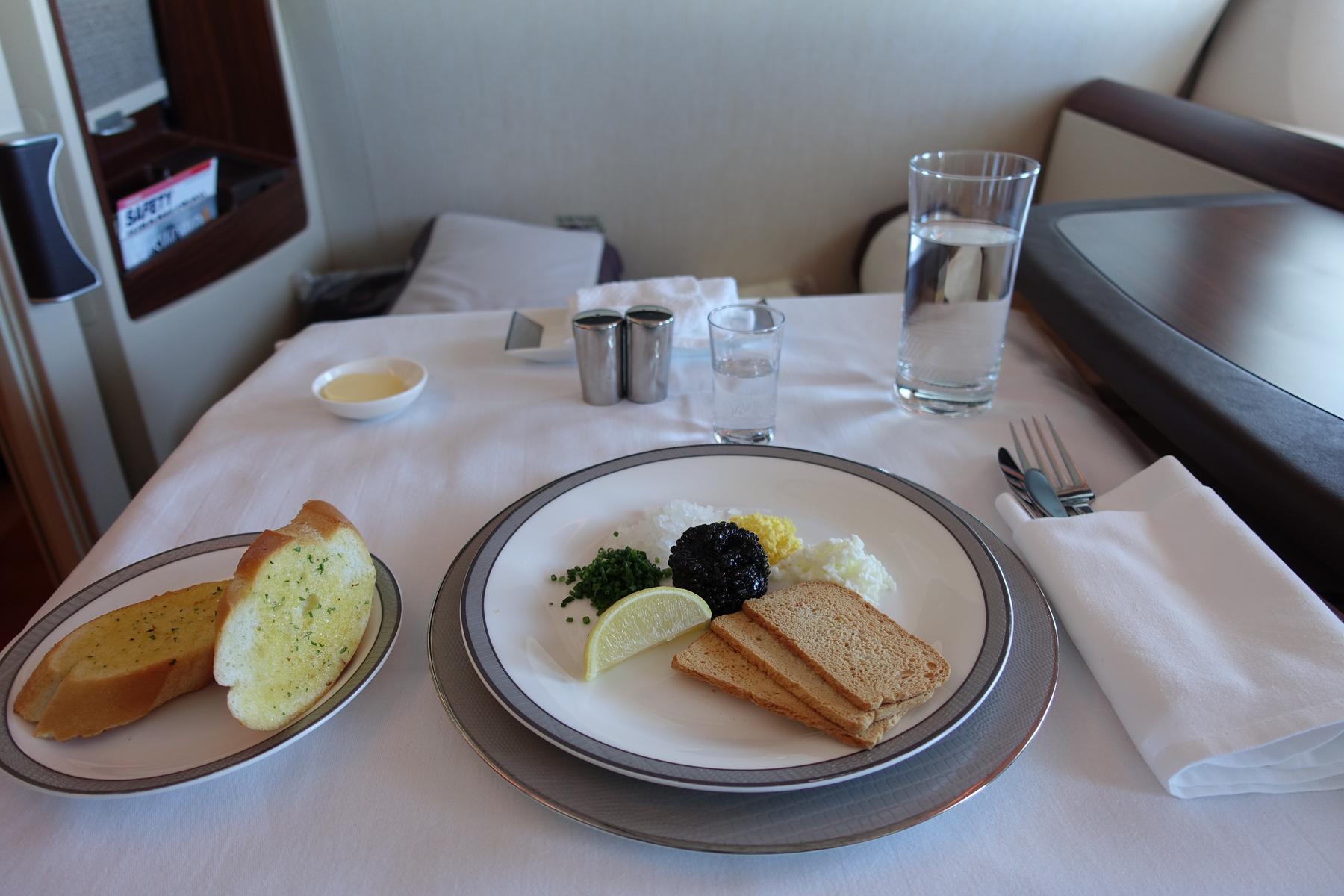 A caviar service with garlic bread laid out on a table in a Singapore Airlines First Class Suite.