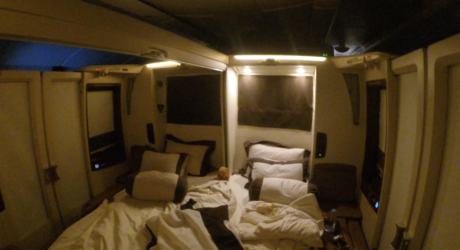A luxurious double bed set up inside a private Singapore Airlines First Class Suites cabin.