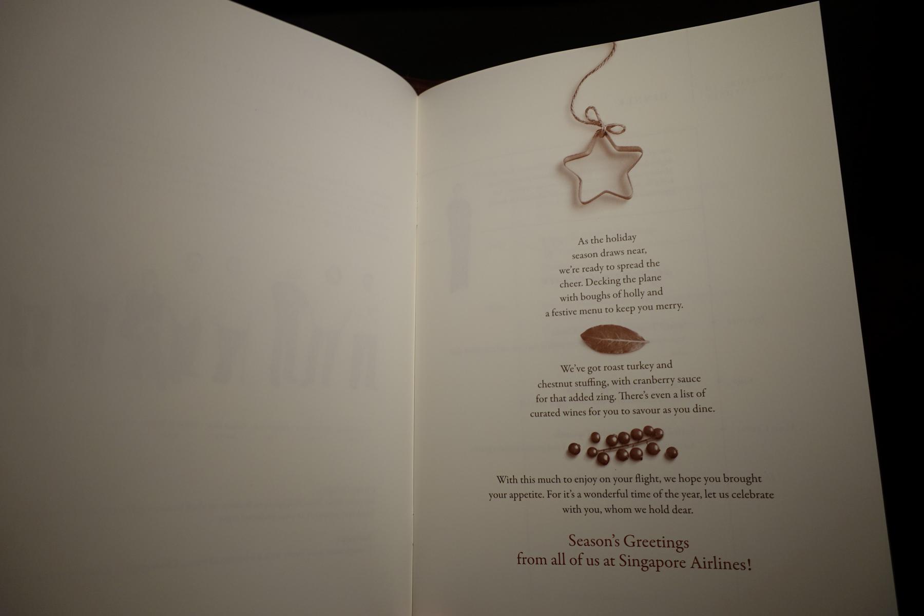 An open page from a Singapore Airlines Christmas menu, featuring festive text and illustrations.