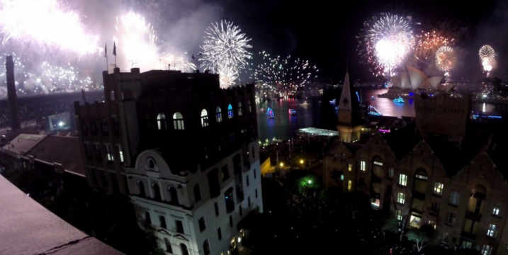 Fireworks explode over Sydney Harbour with the Opera House visible at night.