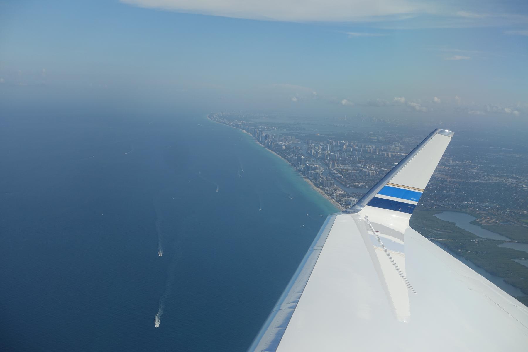 Private jet wing overlooking the South Beach coastline, ocean, and city.