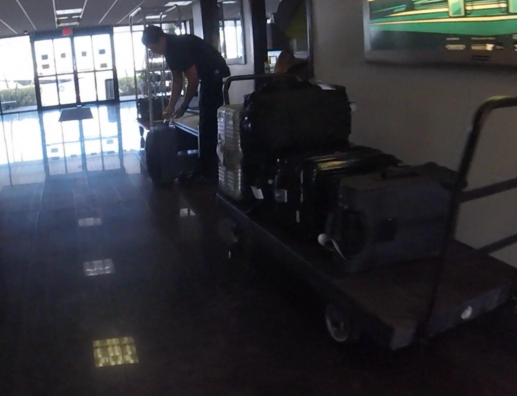 A man sorts a large amount of luggage on carts in a private jet terminal.