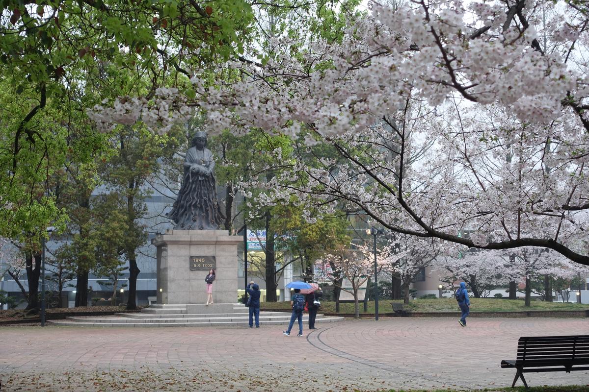 Mother and Child Statue surrounded by cherry blossoms in Nagasaki Peace Park.