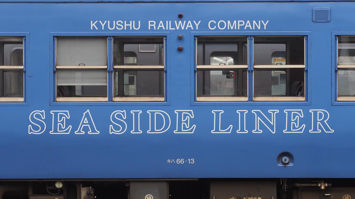 Blue train car with "Kyushu Railway Company" and "SEA SIDE LINER" text.