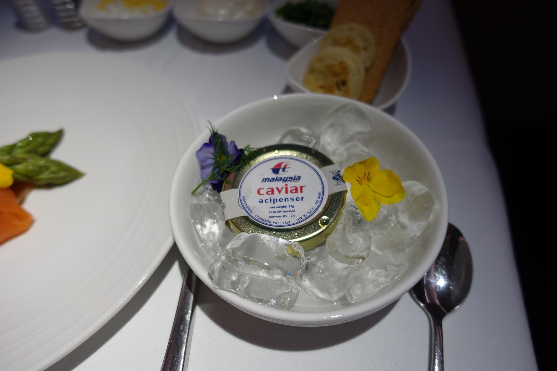A tin of Malaysia Airlines caviar is presented on ice with decorative flowers, as part of a First Class meal.
