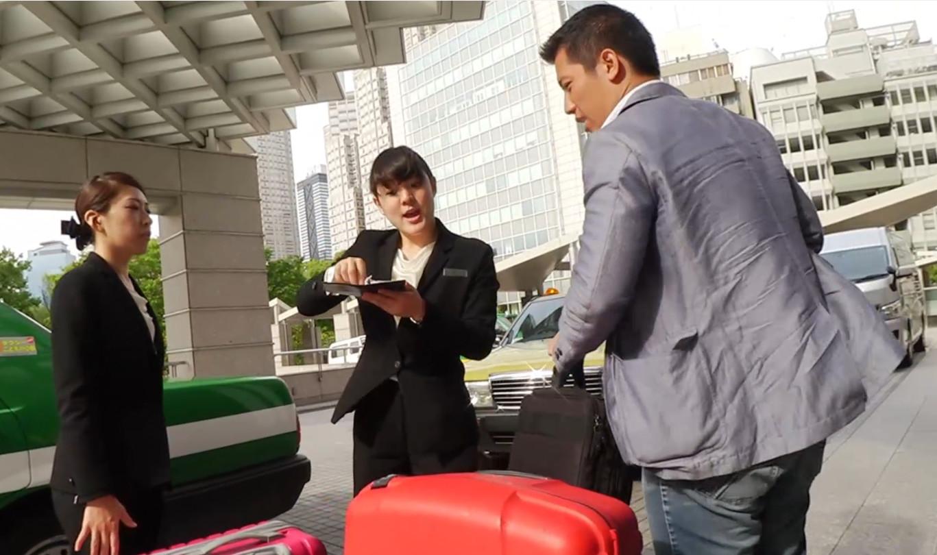 Hotel staff assist a male guest with luggage outside the Park Hyatt Tokyo.