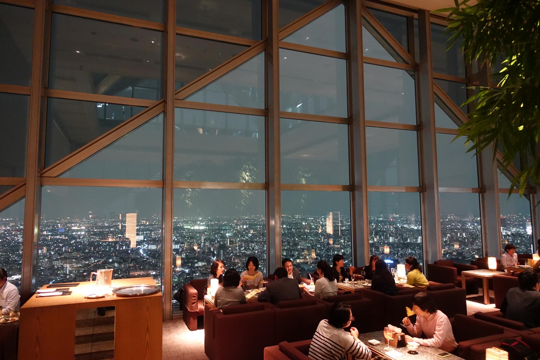 Guests enjoying drinks and the Tokyo city lights from the Park Hyatt Tokyo's New York Bar.