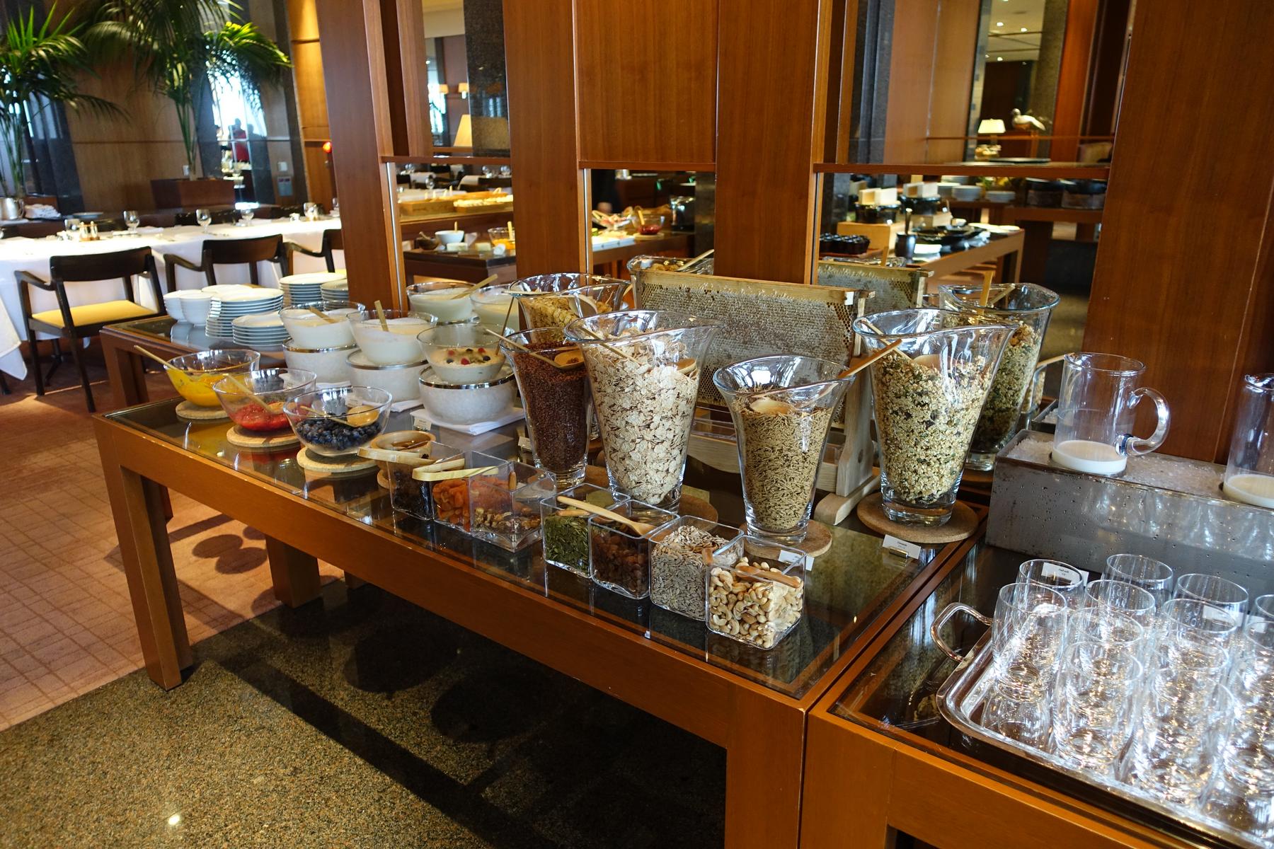 A breakfast buffet at the Park Hyatt Tokyo featuring cereals, nuts, dried fruits, yogurt, and a honeycomb.