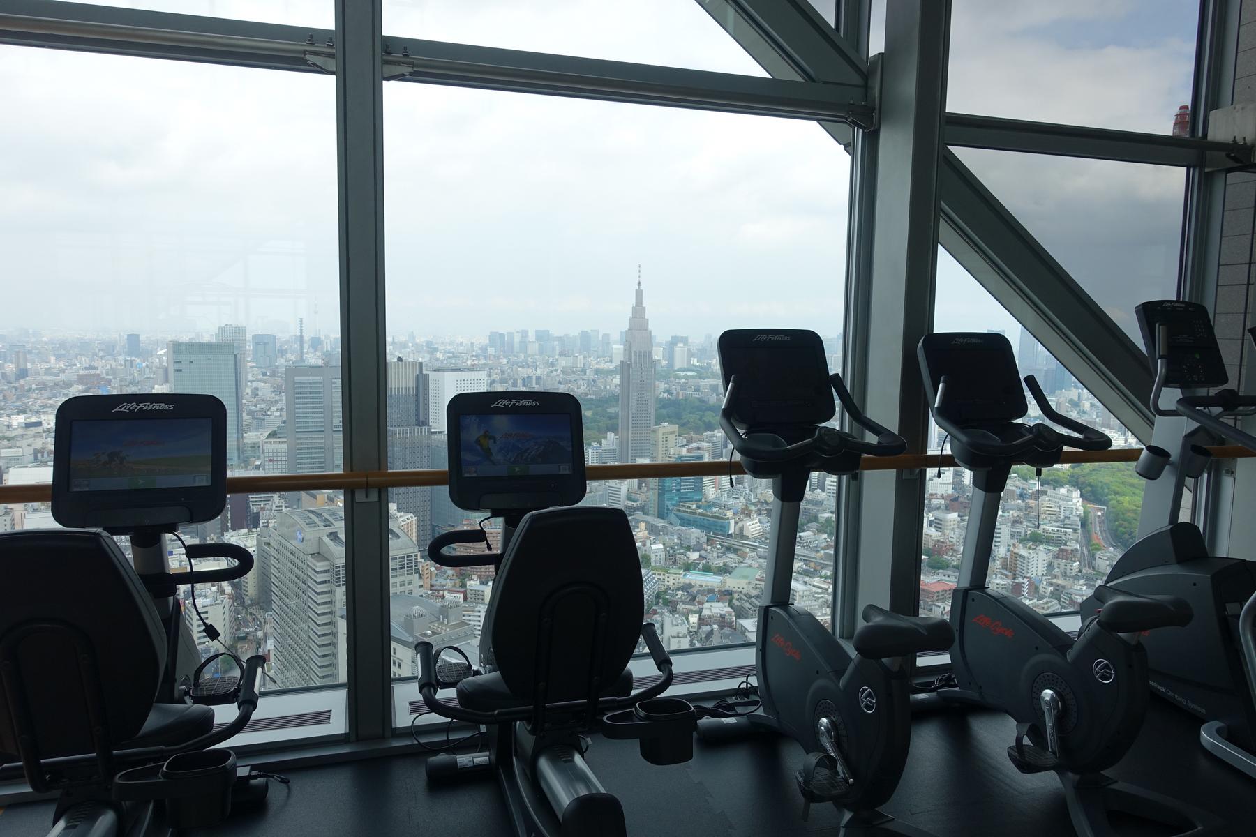 Gym with exercise bikes offering a panoramic view of the Tokyo skyline.