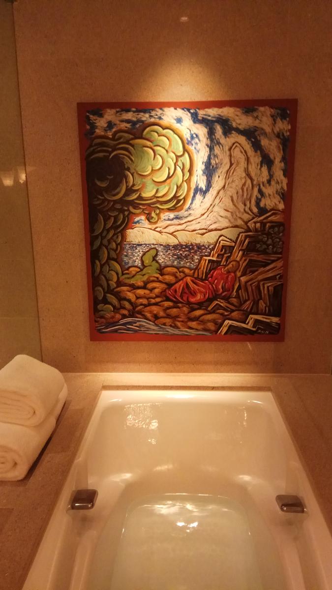 A vibrant painting of a person in red in a dramatic landscape hangs above a bathtub filled with water.